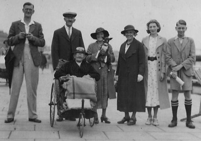 Three generation family photo on a day out along a seaside promenade